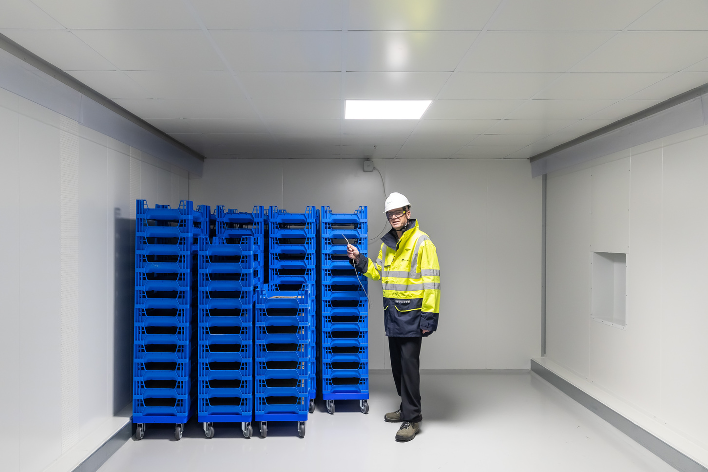 Gert Boersma staat in een kweekcel van uienvliegen. In de kweekbakken die in de cel staan zitten eitjes en voedsel. De sensor in de hand van Gert meet de condities in de kweekruimte.
