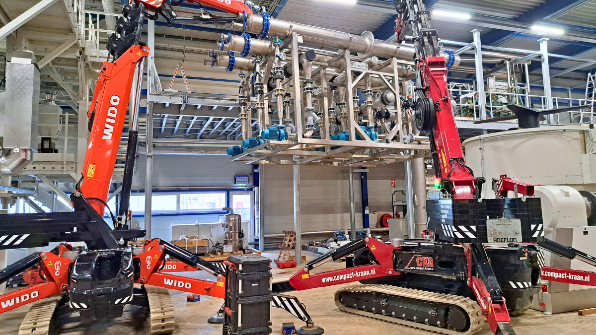 Kranen hijsen de skid op het bordes in de fabriek van Cirrec.